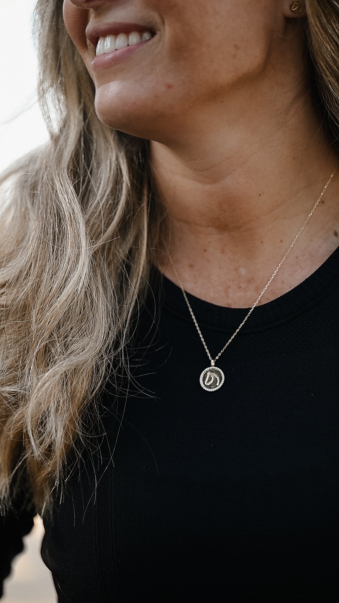 Gold TGH Circle Medallion Pendant Necklace with a Diamond Border, on a model wearing a black shirt.