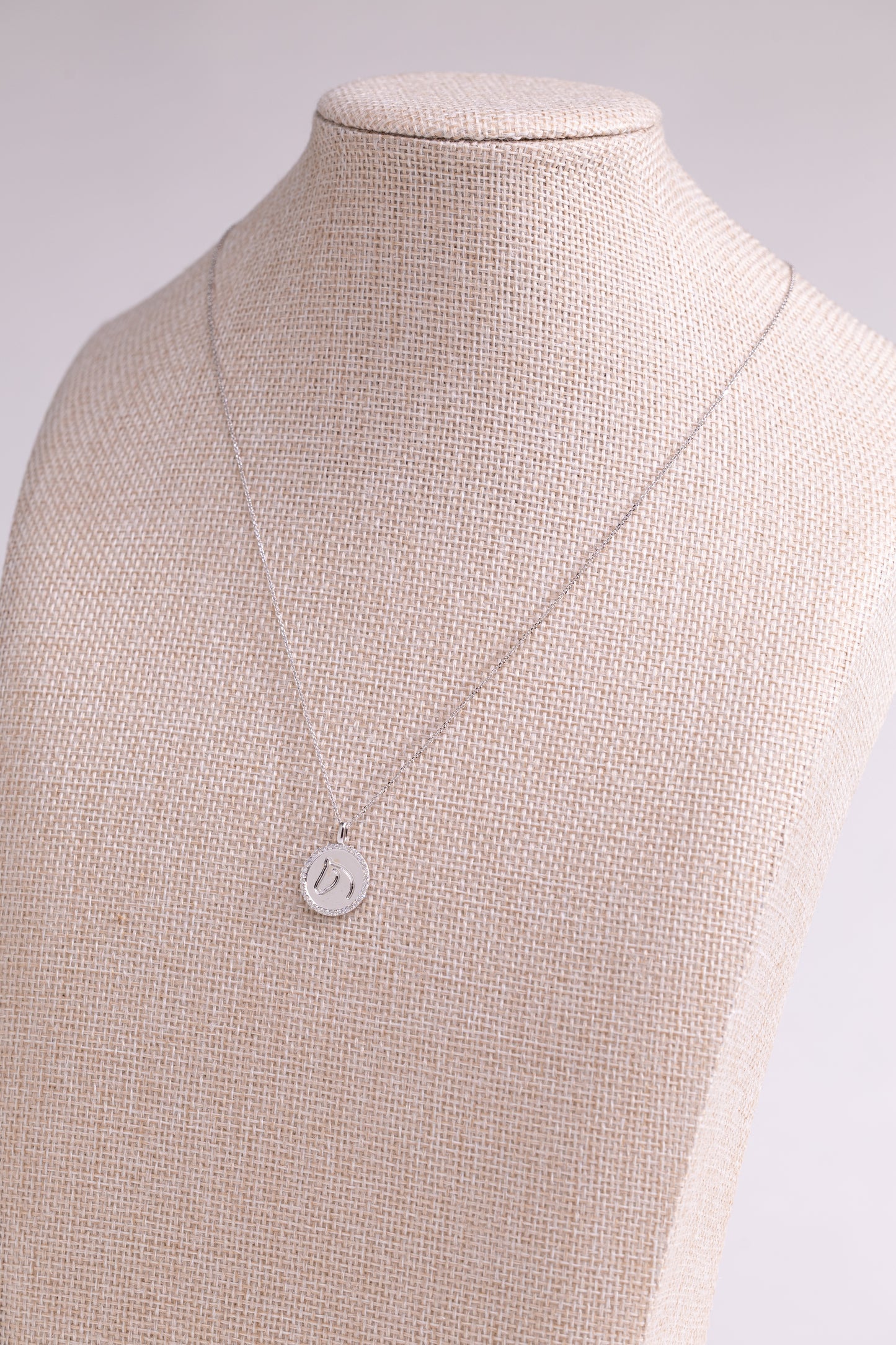 White Gold TGH necklace with diamonds on a beige mannequin.