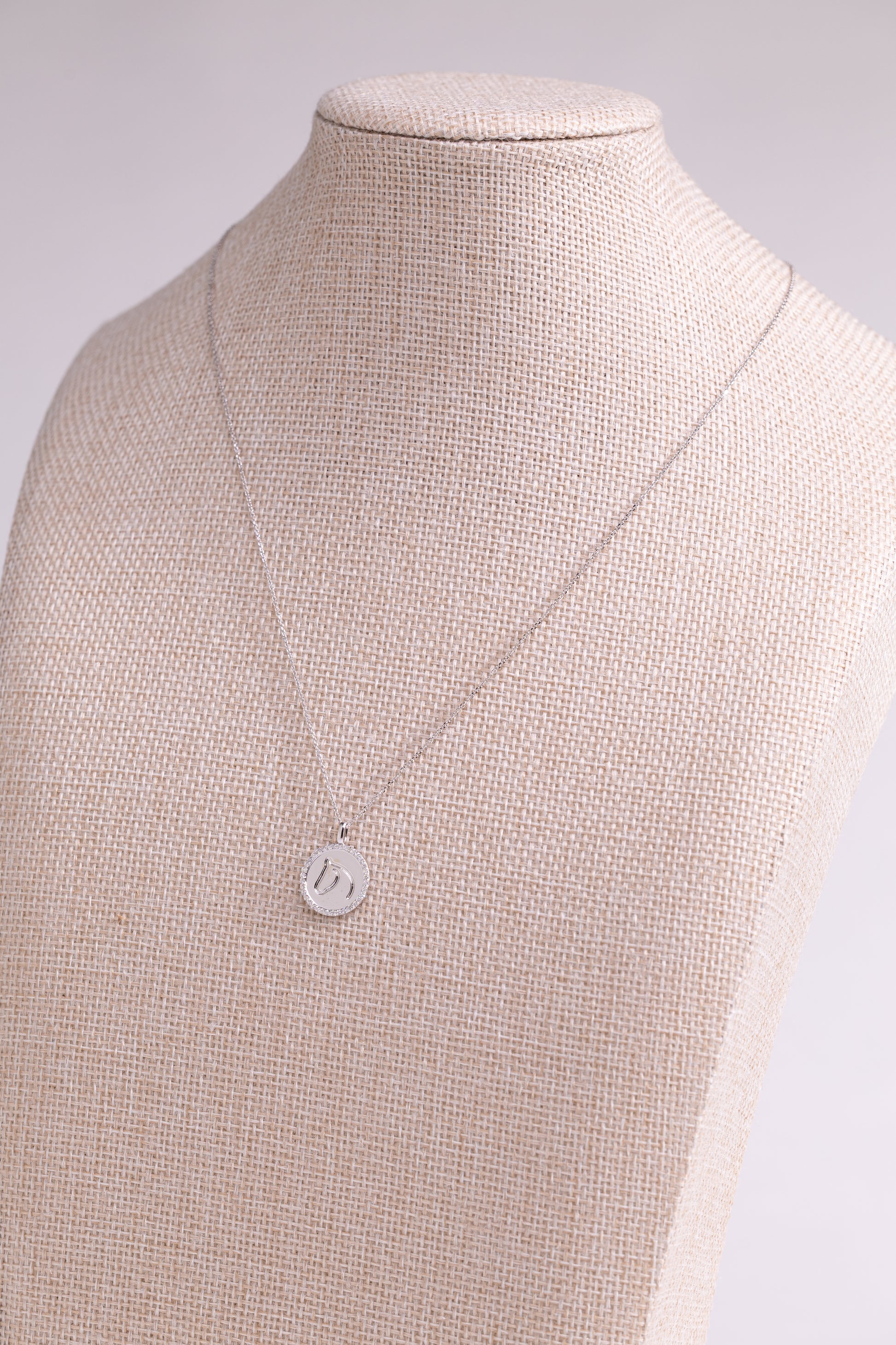 White Gold TGH necklace with diamonds on a beige mannequin.