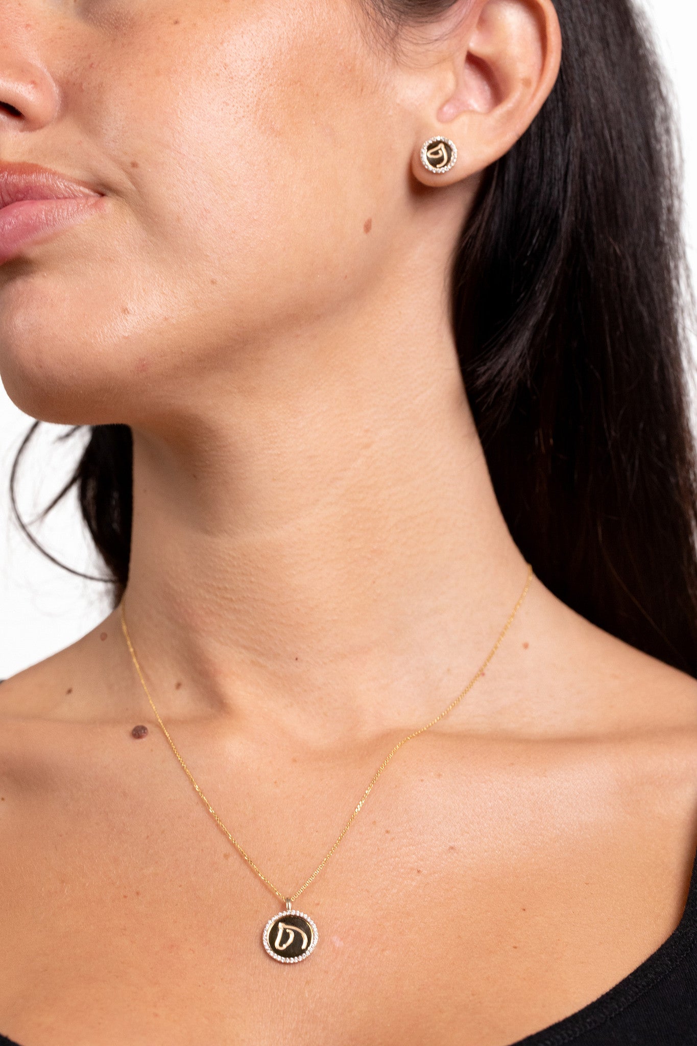 Woman wearing a gold-tone diamond-border Circle Medallion horse necklace and matching studs