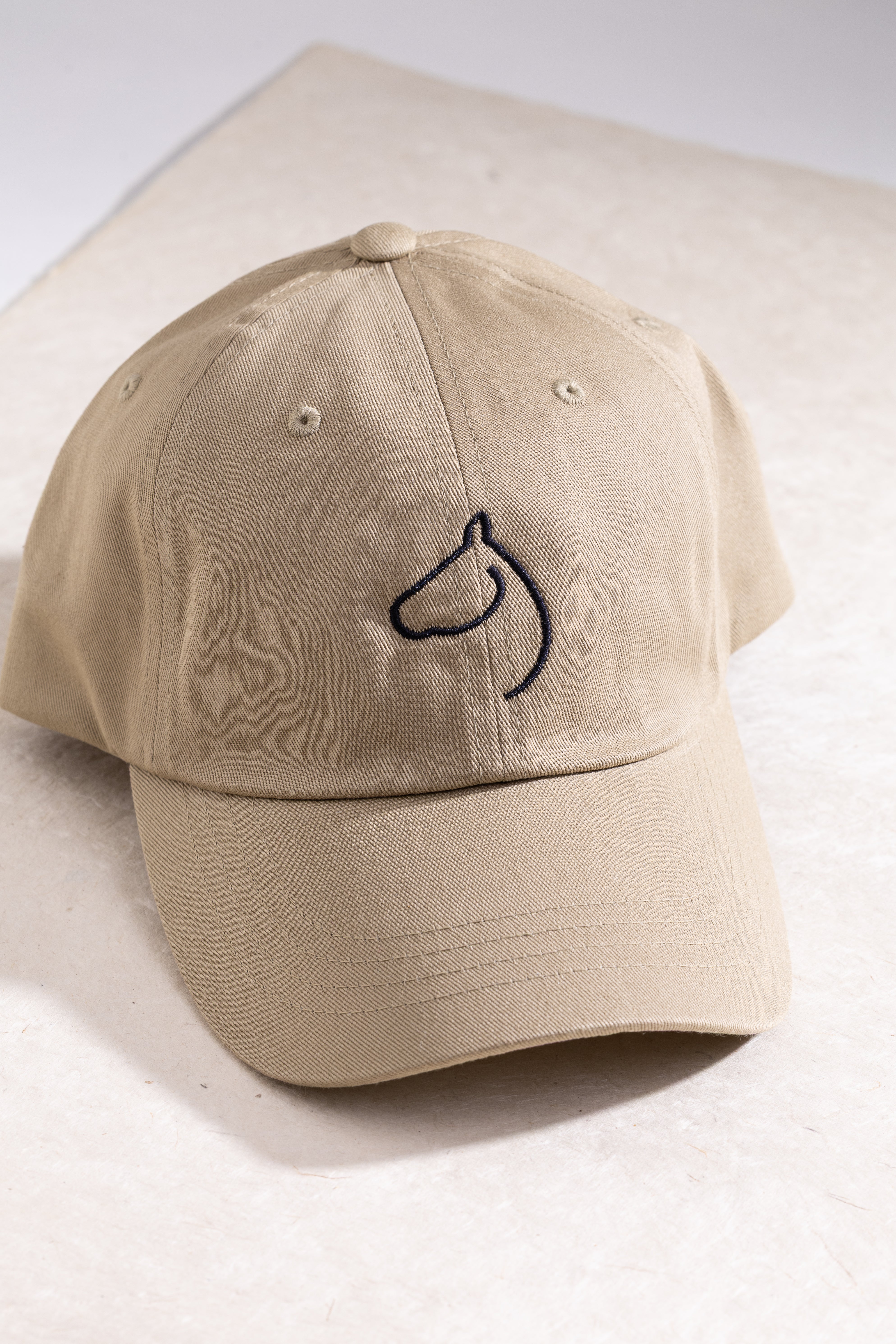 Branded khaki colored hat from The Gilded Horse.