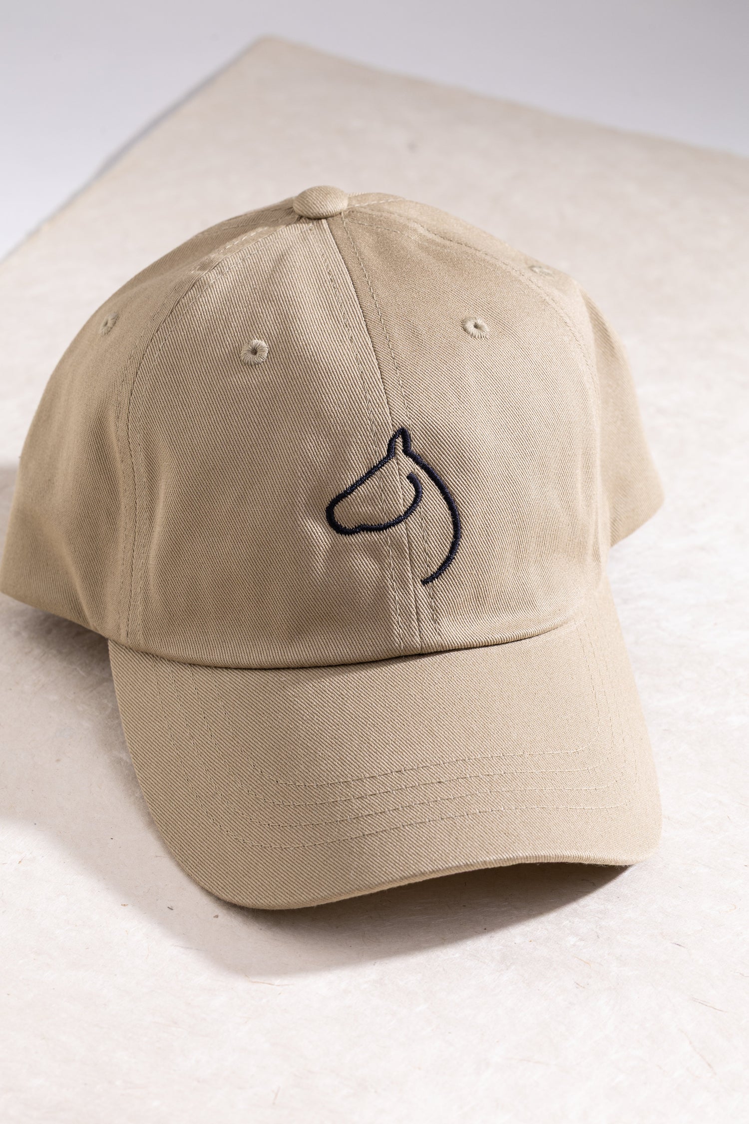 Branded khaki colored hat from The Gilded Horse.
