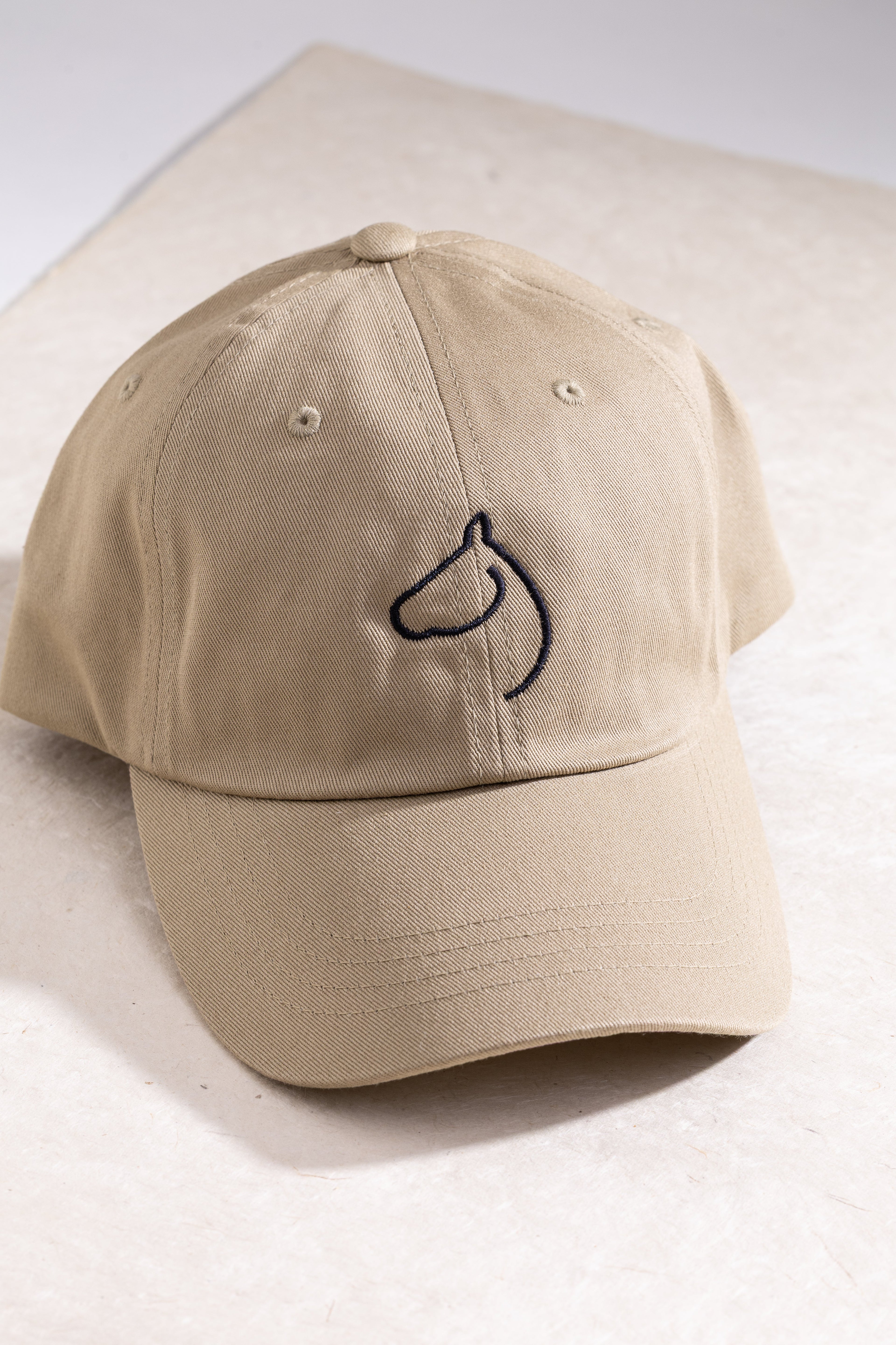Khaki baseball cap embroidered with The Gilded Horse horse-head logo