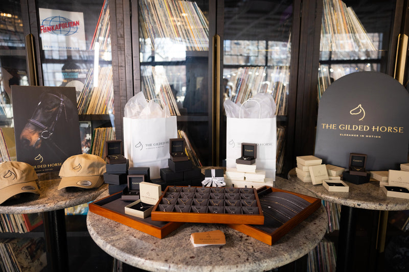 The Gilded Horse jewelry showroom display with cases of horse jewelry and a branded sign