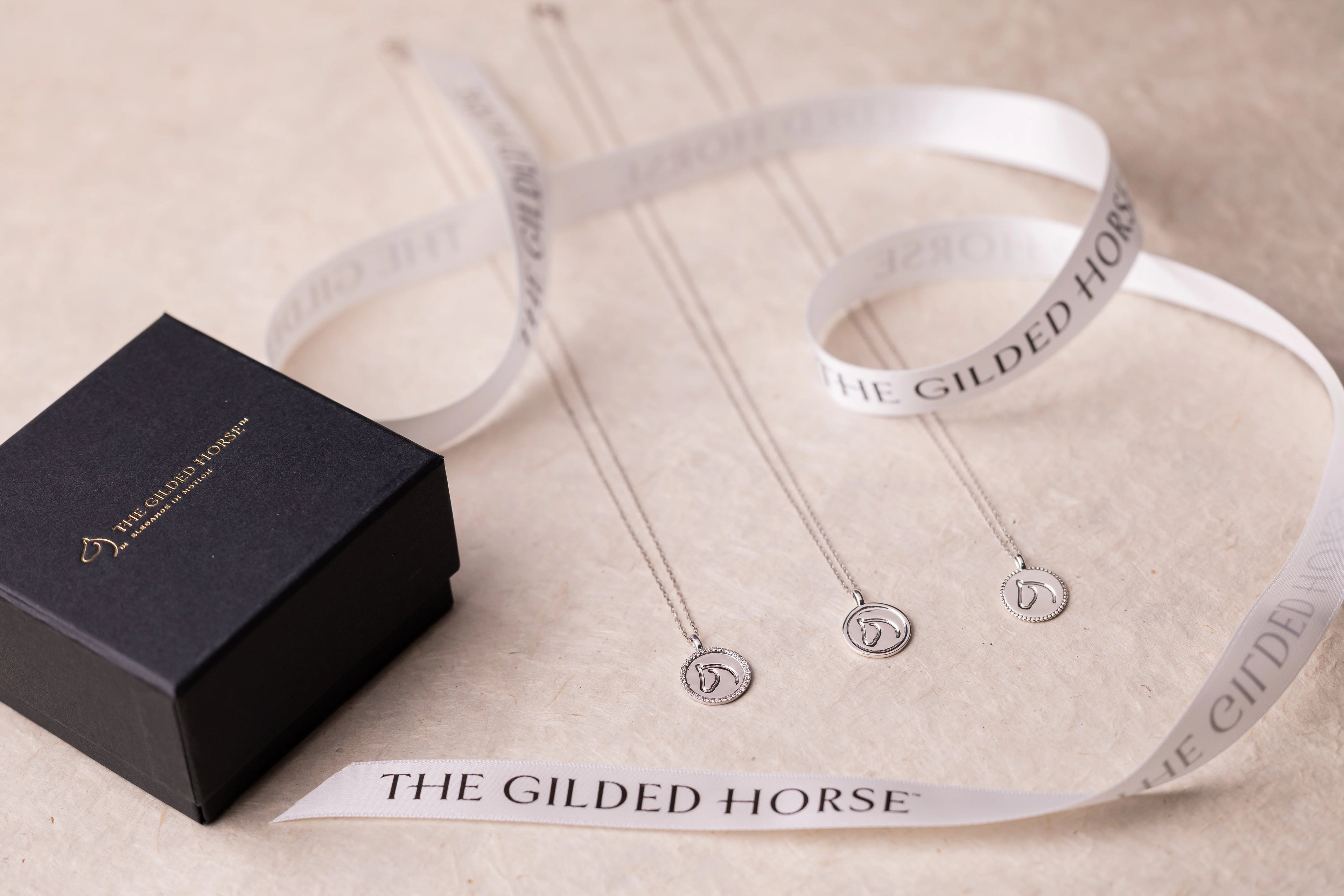 The Gilded Horse showroom display table styled with jewelry, boxes and a cap
