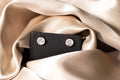 The Gilded Horse silver-tone horse-head stud earrings on a black card over champagne satin