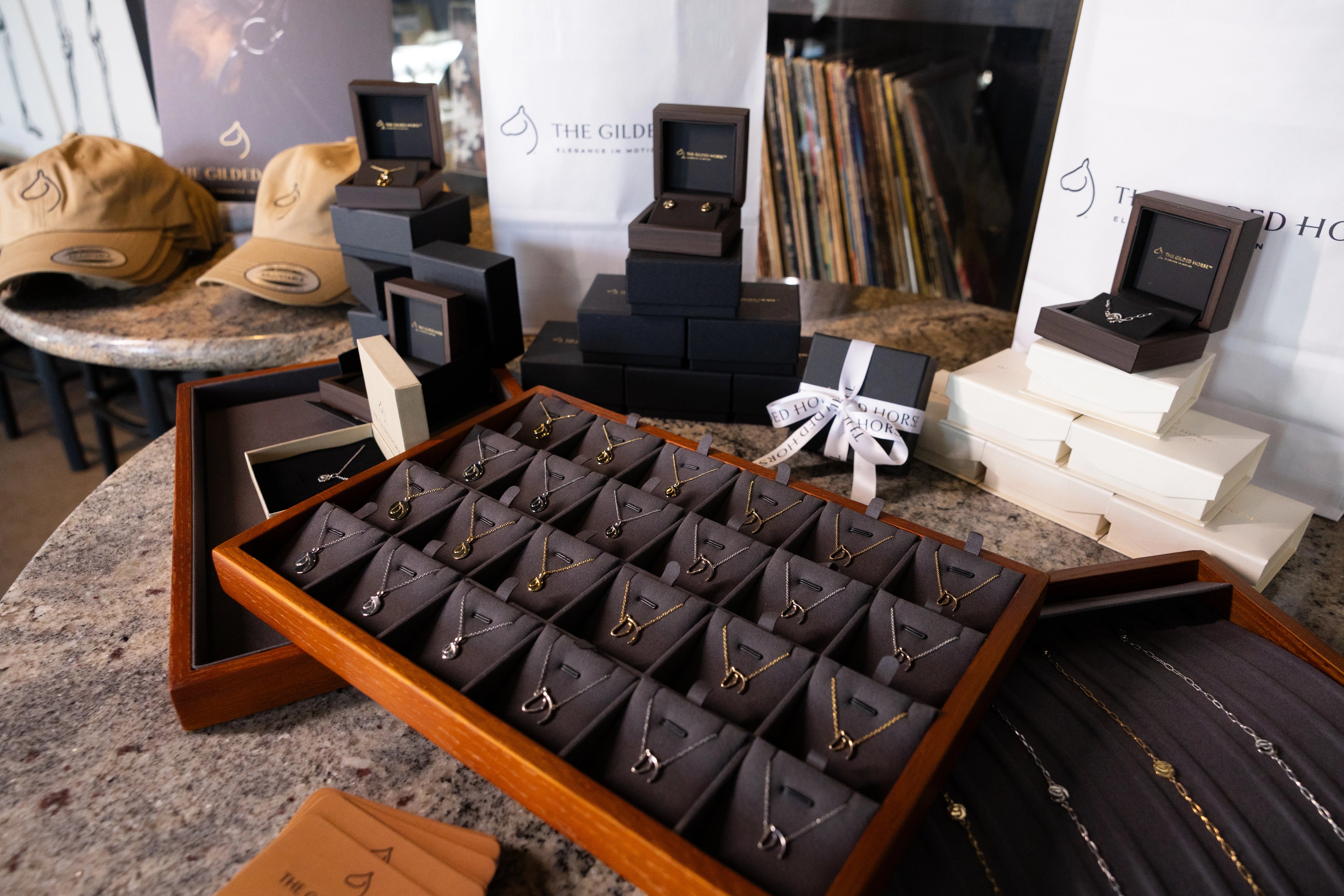 The Gilded Horse retail display of horse necklaces, gift boxes and embroidered caps