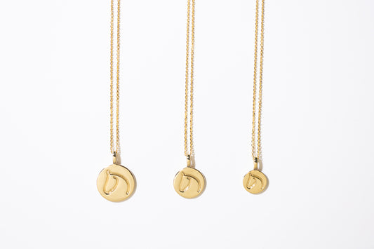 Three Gold Circle Medallion Pendant Necklaces from the The Gilded Horse (Large, Medium & Small) on a white background.