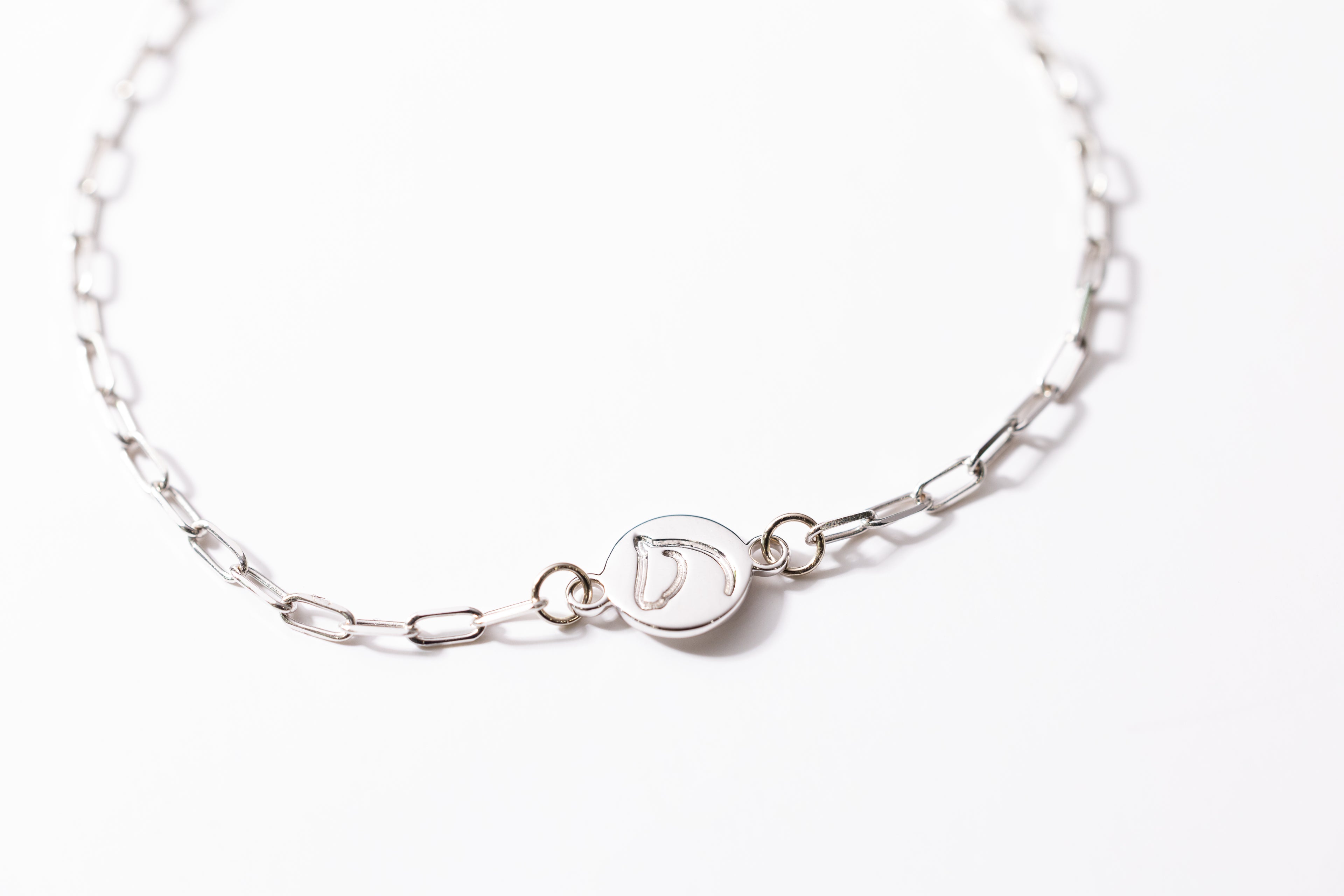 Silver bracelet with a clasp on a white background