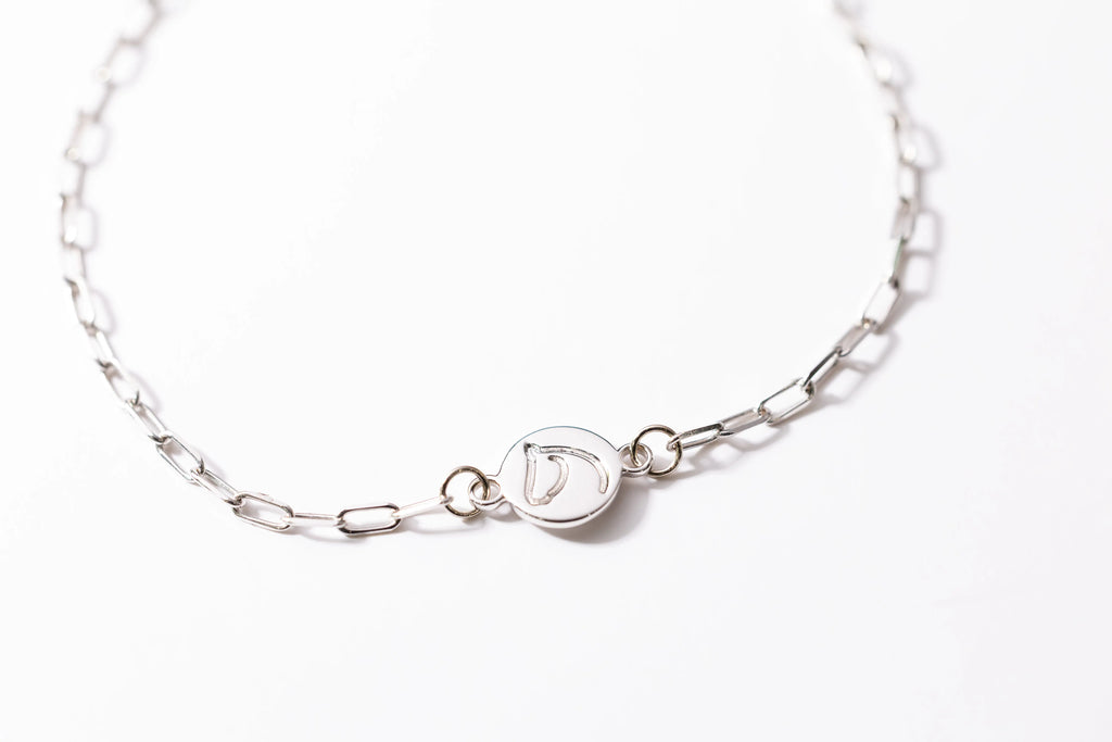 Silver bracelet with a clasp on a white background