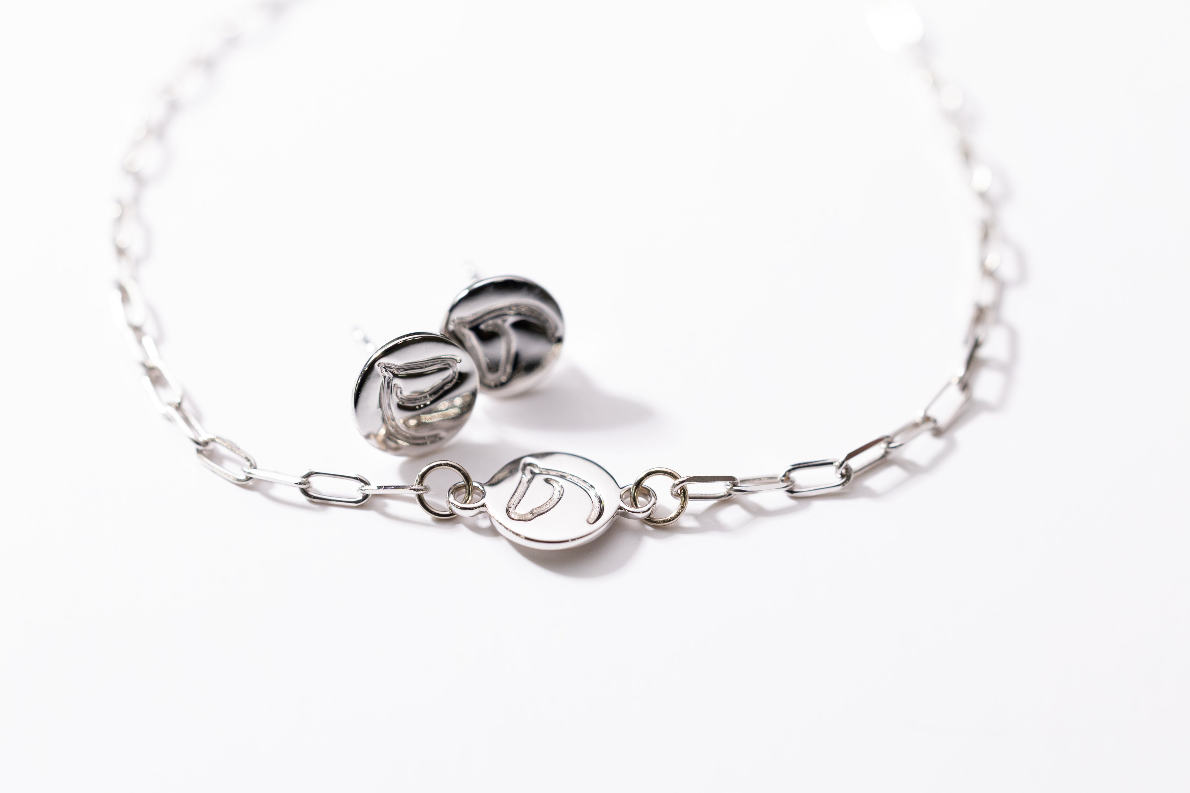 Silver bracelet and earrings on a white background