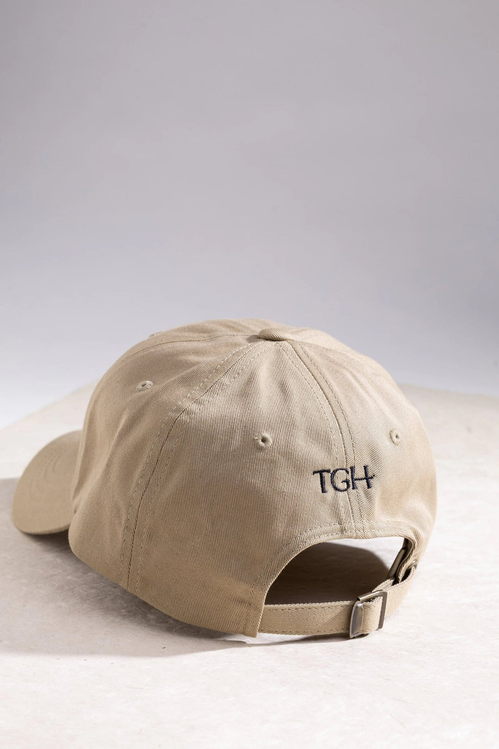 Back of The Gilded Horse khaki dad hat showing TGH embroidery and adjustable strap