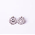 Pair of silver earrings with circular designs on a white background