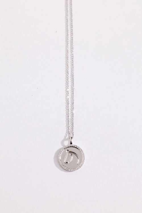 White gold and diamond necklace with a round pendant on a white background.