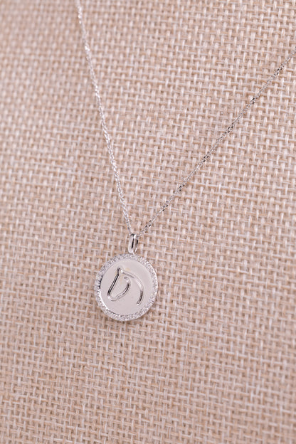 White gold TGH necklace with diamonds on a beige fabric background.