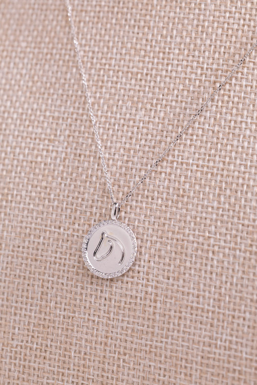 White gold TGH necklace with diamonds on a beige fabric background.
