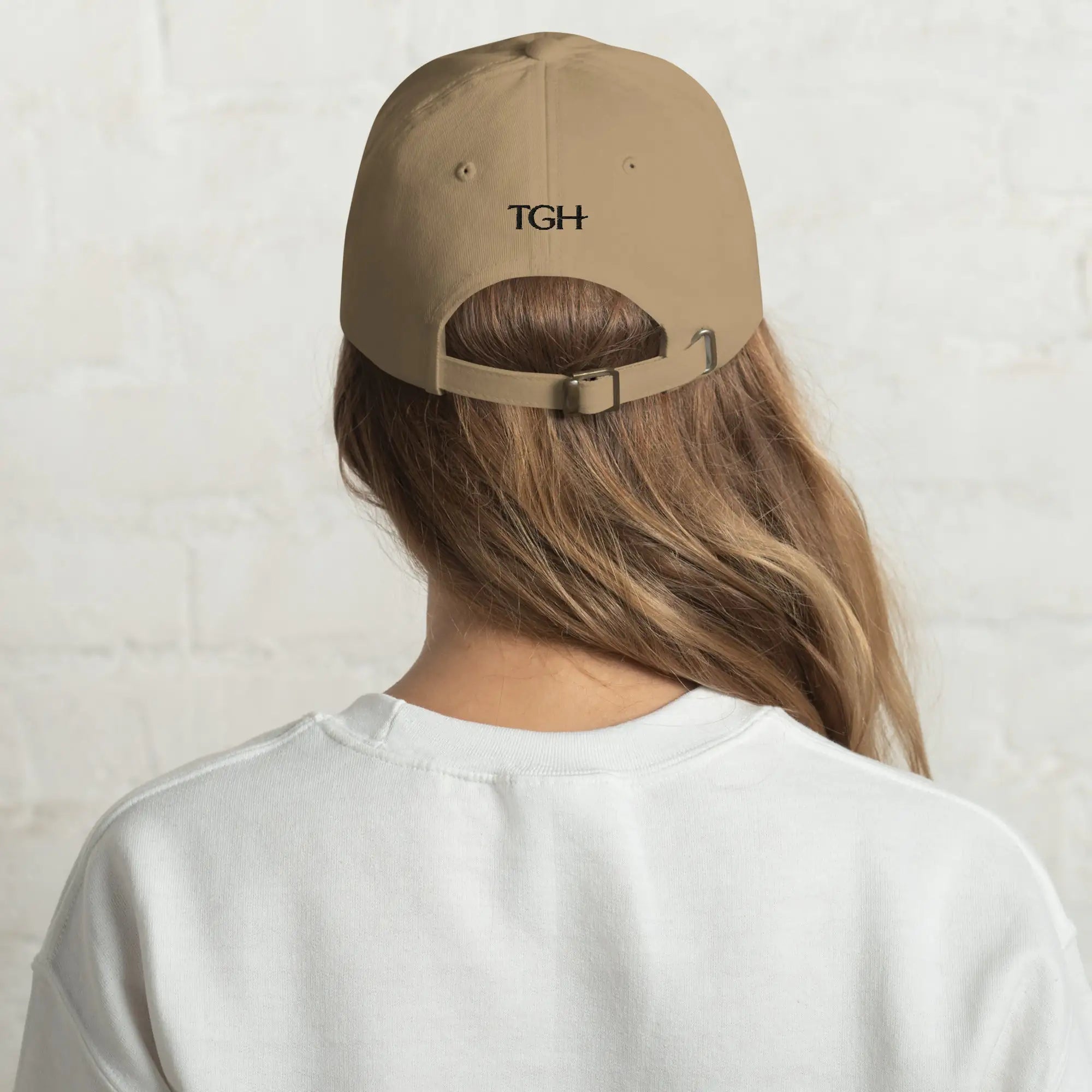 Back of The Gilded Horse khaki dad hat on a woman, black TGH embroidery