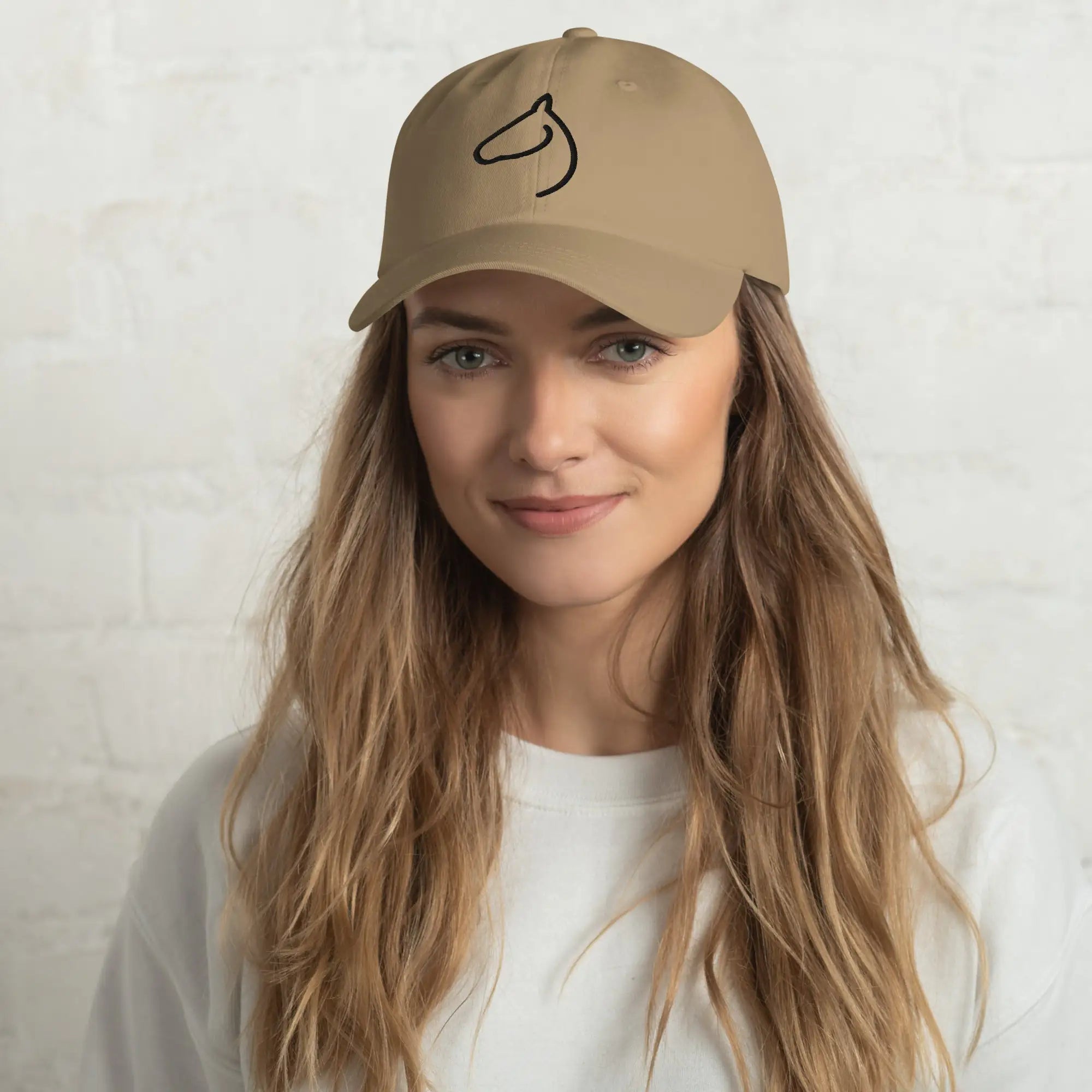 Woman in The Gilded Horse khaki dad hat with black embroidered horse-head logo
