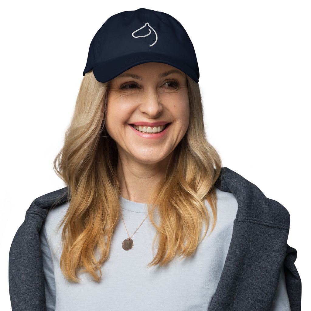 Smiling woman wearing The Gilded Horse navy horse-head cap and a gold pendant necklace